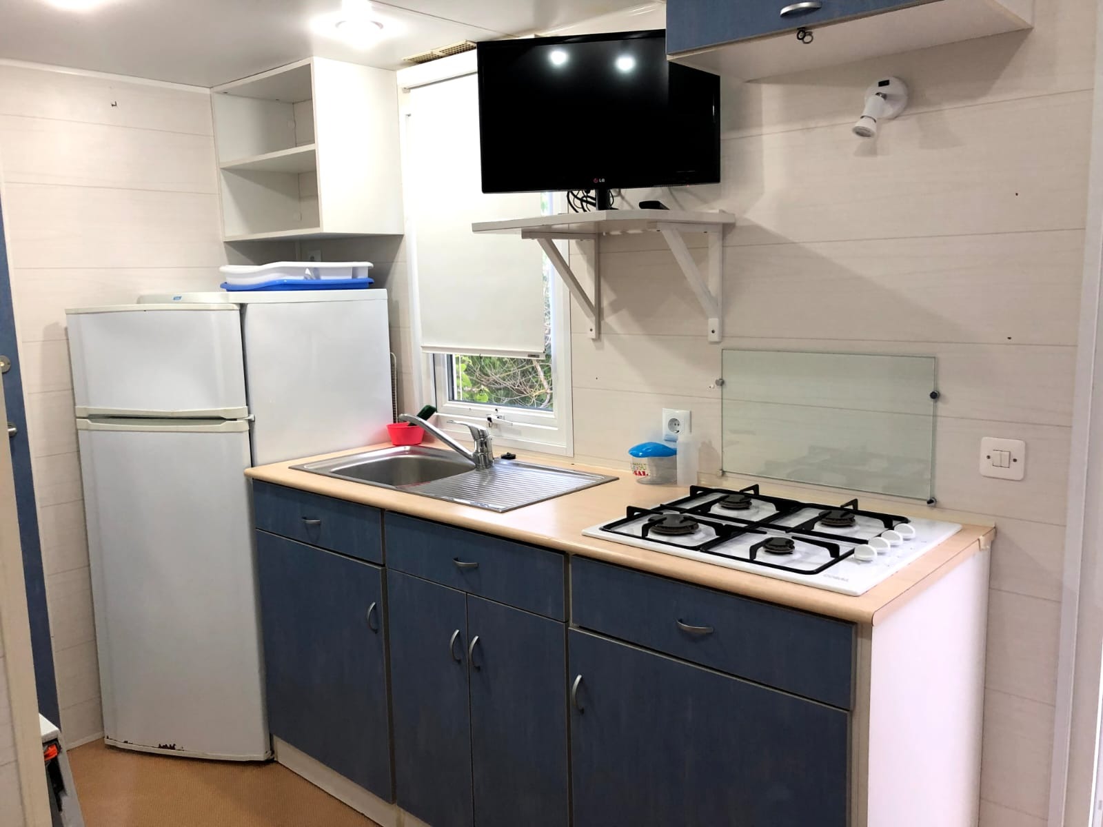 Cocina equipada con frigorífico, fogones y TV