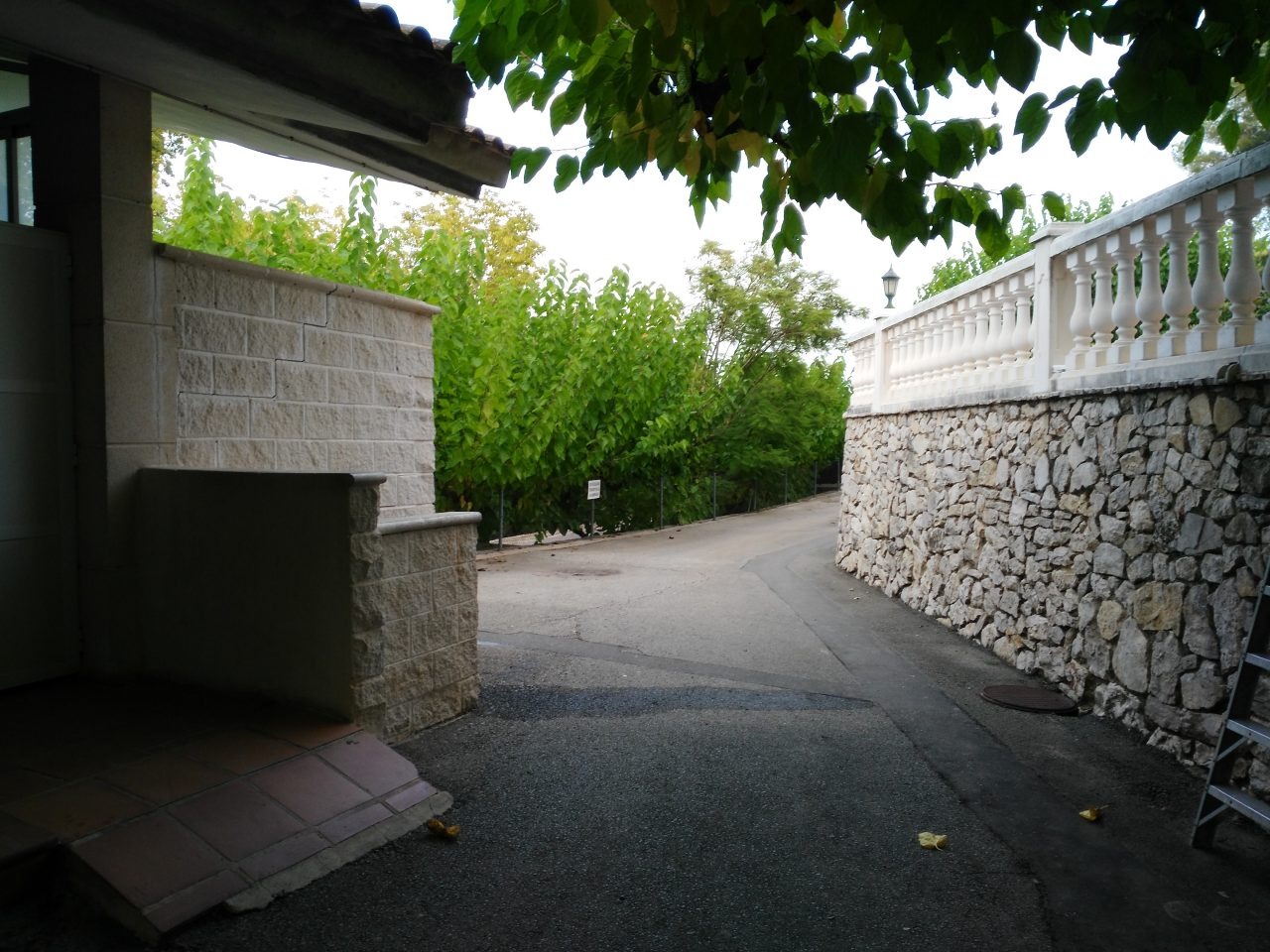 Acceso a los vestuarios con muro de piedra y baranda blanca
