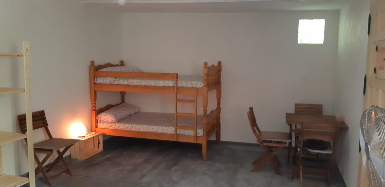 Habitación con litera de madera y mesa