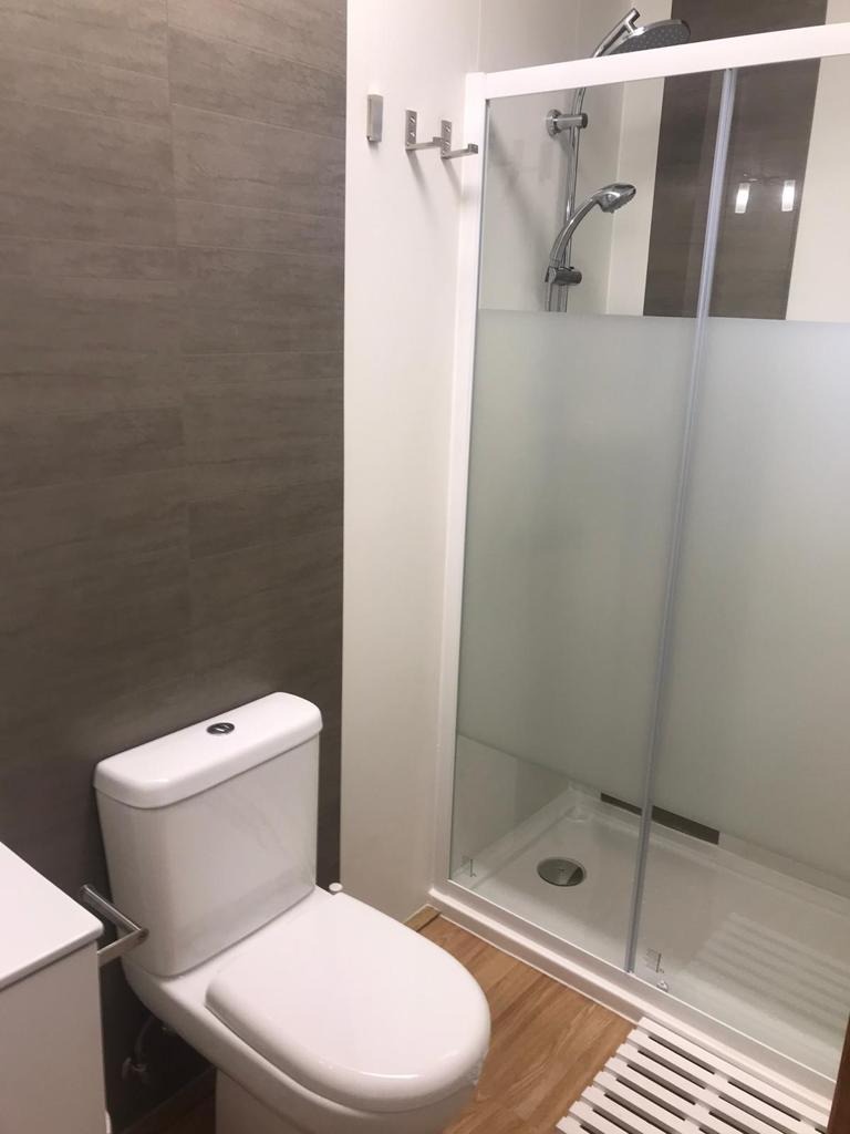 Baño moderno con ducha de cristal y WC